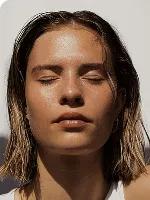 Woman with her eyes closed in the sunlight